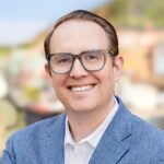 Headshot of Adam Lee, Chief Business Development Officer at AdCellerant, in formal attire, smiling confidently against a plain background.